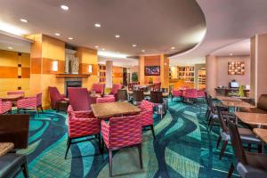 a restaurant with tables and chairs and a fireplace at SpringHill Suites Laredo in Laredo