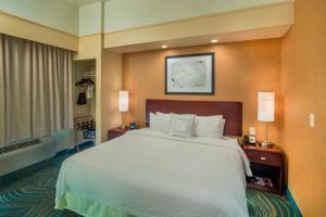 a hotel room with a large bed and two lamps at SpringHill Suites Laredo in Laredo