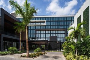 un edificio de oficinas con palmeras delante en AC Hotel by Marriott Kingston, Jamaica en Kingston