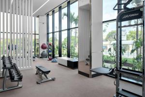 a gym with cardio equipment in a building with windows at AC Hotel by Marriott Kingston, Jamaica in Kingston