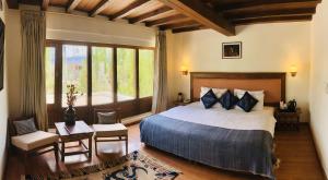 a bedroom with a large bed and a large window at Hotel Kang Lha Chen in Leh