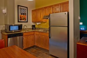 a kitchen with a stainless steel refrigerator and wooden cabinets at Residence Inn by Marriott Hartford Downtown in Hartford