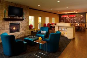 a living room with blue chairs and a fireplace at TownePlace Suites Houston North/Shenandoah in The Woodlands