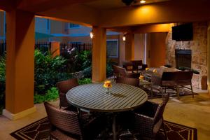 a patio with a table and chairs and a fireplace at TownePlace Suites Houston North/Shenandoah in The Woodlands