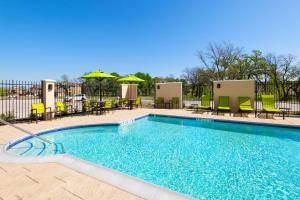 a swimming pool with chairs and tables and umbrellas at SpringHill Suites by Marriott Weatherford Willow Park in Willow Park
