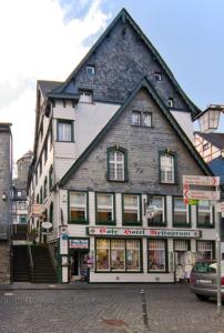 un grand bâtiment au coin d'une rue dans l'établissement Burghotel, à Monschau