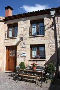 a building with a table and two benches in front of it at La Cabaña in Mozoncillo de Juarros