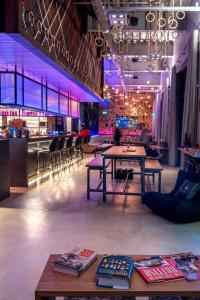 una habitación con mesas y sillas y un bar en Moxy London Stratford, en Londres