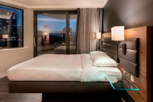 a bedroom with a large bed with a window at Moxy London Stratford in London