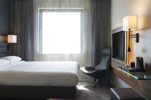 a hotel room with a bed and a television at Moxy London Stratford in London