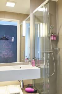 a bathroom with a sink and a shower at Moxy London Stratford in London