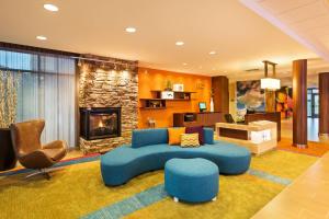 Fairfield Inn & Suites by Marriott Johnson City في جونسون سيتي: غرفة معيشة مع أريكة زرقاء ومدفأة