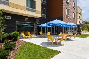 a patio with chairs and tables with umbrellas at Fairfield Inn & Suites by Marriott Johnson City in Johnson City