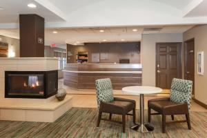 a lobby with a fireplace and a table and chairs at Residence Inn Phoenix Chandler/Fashion Center in Chandler