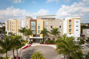ケンドールにあるTownePlace Suites Miami Kendall Westのヤシの木が前に浮かぶホテルの様子