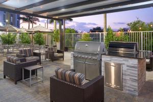 d'une terrasse avec un barbecue, des chaises et des tables. dans l'établissement TownePlace Suites Miami Kendall West, à Kendall