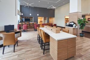 a lobby with a cafeteria with tables and chairs at TownePlace Suites Miami Kendall West in Kendall