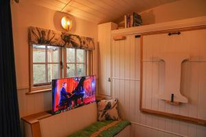 a tv in a corner of a room with a window at Shepherds Hut in countryside near Bath and Bristol in Bristol