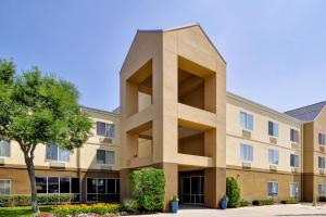 ein braunes Gebäude mit einem Baum davor in der Unterkunft Fairfield Inn & Suites Dallas Medical/Market Center in Dallas