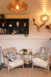 uma sala de estar com duas cadeiras e uma mesa em Shepherds Hut in countryside near Bath and Bristol em Bristol