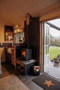 uma cozinha com uma porta aberta para uma cozinha com um fogão em Shepherds Hut in countryside near Bath and Bristol em Bristol