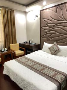 a hotel room with a bed and a desk at Holiday Hotel in Hai Phong