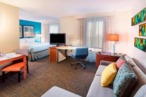 a hotel room with a couch and a desk and a bed at Residence Inn Huntsville in Huntsville