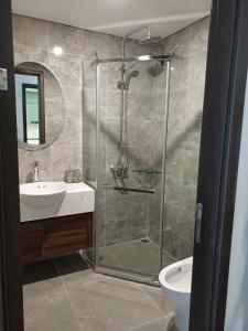 a bathroom with a shower and a sink and a toilet at Holiday Hotel in Hai Phong