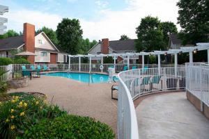 a swimming pool with a white fence next to a house at Residence Inn by Marriott Spartanburg in Spartanburg