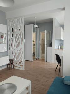 a living room with a white partition with a table at Maestro in Wyszków