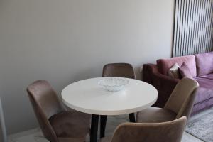 a dining room with a white table and chairs at Inter Holiday Apartments in Pomorie