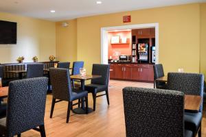 a restaurant with tables and chairs and a kitchen at TownePlace Suites Stafford in Stafford