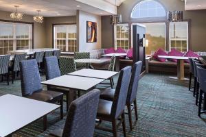a restaurant with tables and chairs and a couch at Residence Inn Huntsville in Huntsville