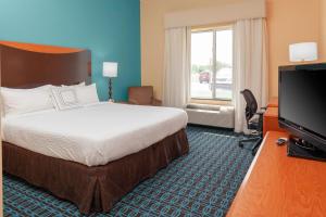 a hotel room with a bed and a flat screen tv at Fairfield Inn and Suites by Marriott Seymour in Seymour