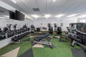 a fitness room with tread machines and a flat screen tv at Element Bentonville in Bentonville