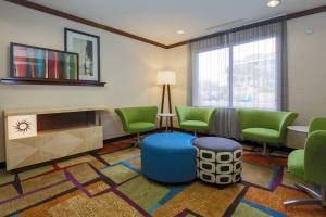 a waiting room with green chairs and a table at Fairfield Inn & Suites Las Vegas South in Las Vegas