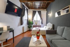- un salon avec un canapé et un lit dans l'établissement Monserrato Apartment, à Rome