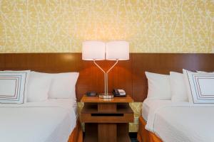 a hotel room with two beds and a lamp on a night stand at Fairfield by Marriott Inn & Suites Las Vegas Stadium Area in Las Vegas