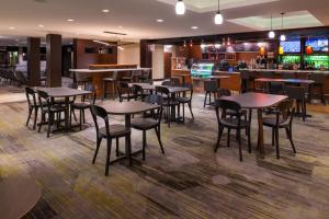 a restaurant with tables and chairs and a bar at Courtyard by Marriott Victorville Hesperia in Hesperia