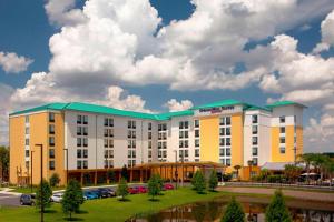 un hotel con un edificio blanco y amarillo en SpringHill Suites by Marriott Orlando at SeaWorld, en Orlando