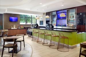 um restaurante com um bar verde com cadeiras e mesas em SpringHill Suites by Marriott Orlando at SeaWorld em Orlando