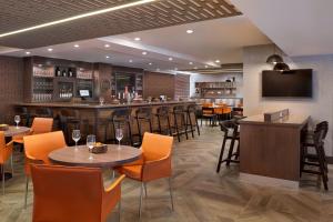 a restaurant with tables and chairs and a bar at Four Points by Sheraton Hamilton - Stoney Creek in Hamilton