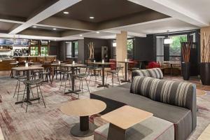 a lobby with tables and chairs and a restaurant at Courtyard by Marriott Dayton North in Dayton
