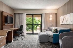a hotel room with a bed and a desk and a chair at Courtyard by Marriott Dayton North in Dayton