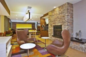 sala de estar con sillas y chimenea en Fairfield by Marriott Southeast Hammond, IN, en Hammond