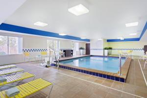 a swimming pool with yellow chairs around it at Fairfield by Marriott Southeast Hammond, IN in Hammond