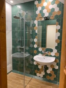 La salle de bains est pourvue d'un lavabo et d'une douche en verre. dans l'établissement Green house Ramuciai, à Ramučiai