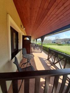 a balcony with a table and chairs on a porch at Apartamenty Pod Debem (Ferienwohnungen an der uralten Eiche) in Wapnica