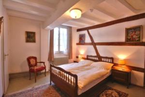 a bedroom with a large bed and a red chair at Burghotel in Monschau