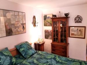 1 dormitorio con 1 cama y armario de madera en château de Beuzeval, golf de Hougate en Gonneville-sur-Mer